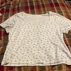 A plain white shirt with green dots and purple roses